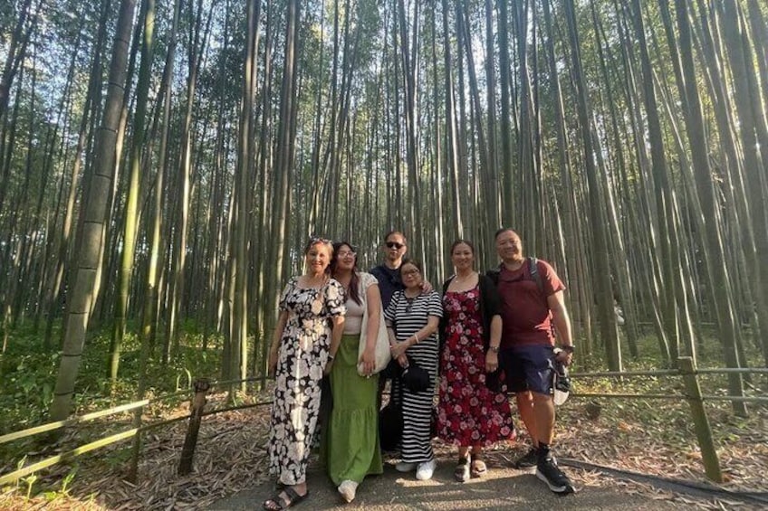 A group of people standing in a bamboo forest. 1