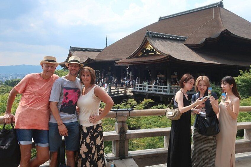 A group of people standing in front of a traditional building with a curved roof. 4