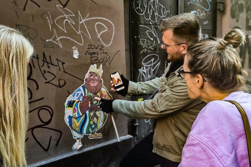 En person fotograferer en graffiti-tegning på en væg. 2