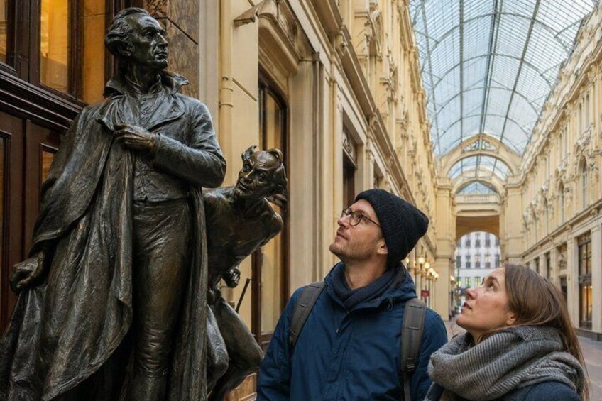 En statue af en historisk person i en overdækket passage. 4