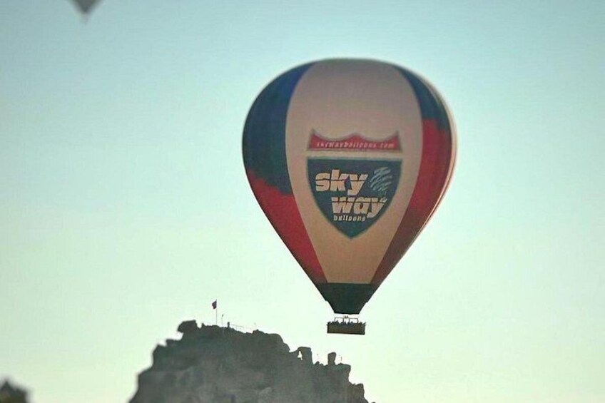 Een luchtballon met het logo 'Sky Way' boven een rotsachtige richel. 5