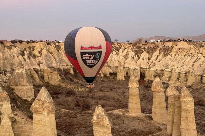 Een luchtballon met 'Sky Way' branding boven een landschap van bijzondere rotsformaties. 2