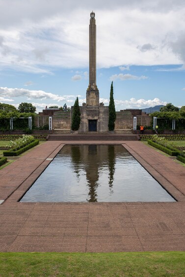 A tall monument with a reflective pool in front. 3