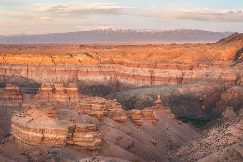 A vast canyon with layered rock formations and distant mountains. 2