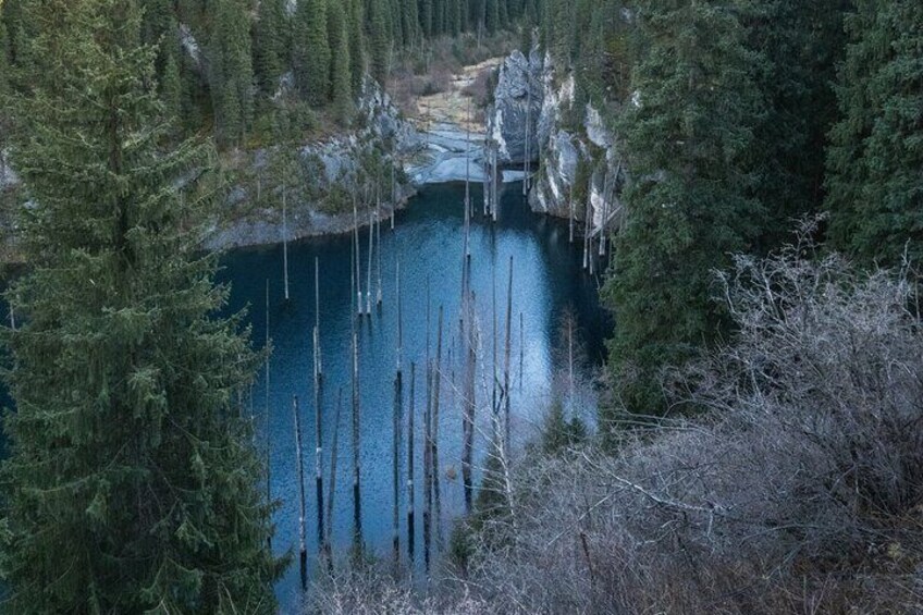 A lake surrounded by dense forest and rocky cliffs. 5