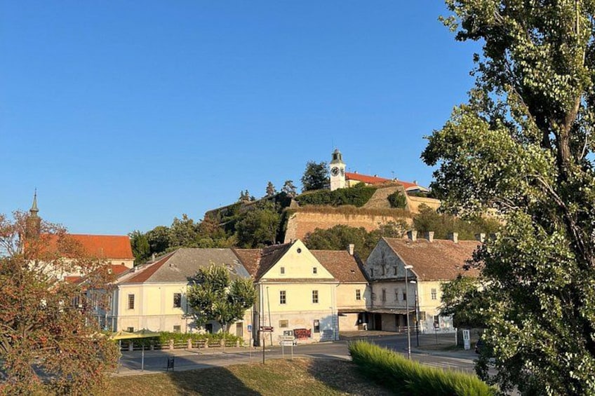 A town with historic buildings, a church, and a hill with a tower. 5