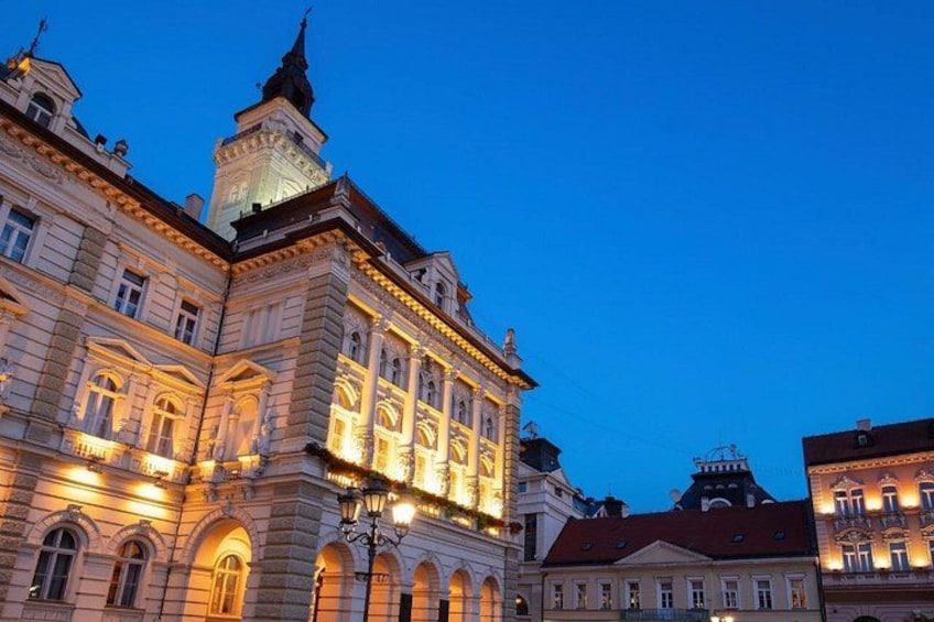 A historic building with ornate architecture and a clock tower, illuminated by warm lighting. 4