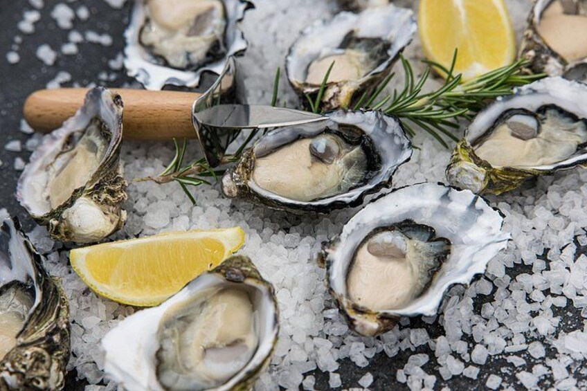 Oysters on ice with lemon wedges and rosemary sprigs. 4
