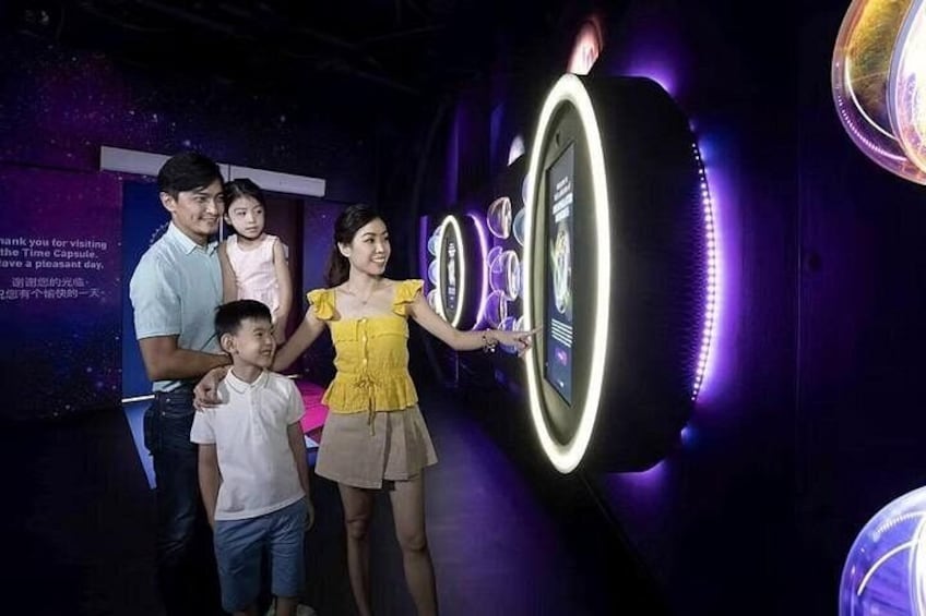 Una famiglia interagisce con un display digitale in un museo. 3