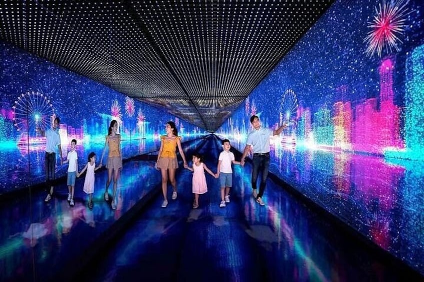 Una famiglia cammina attraverso un tunnel con un'installazione luminosa digitale. 1