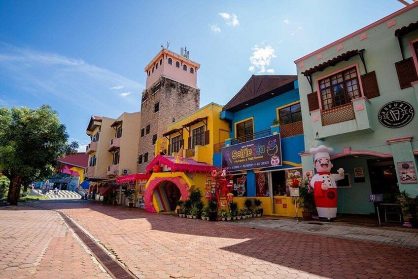 A colorful street with buildings, a large inflatable slide, and a chef statue. 3