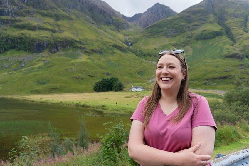 A person standing by a lake with mountains in the background. 3