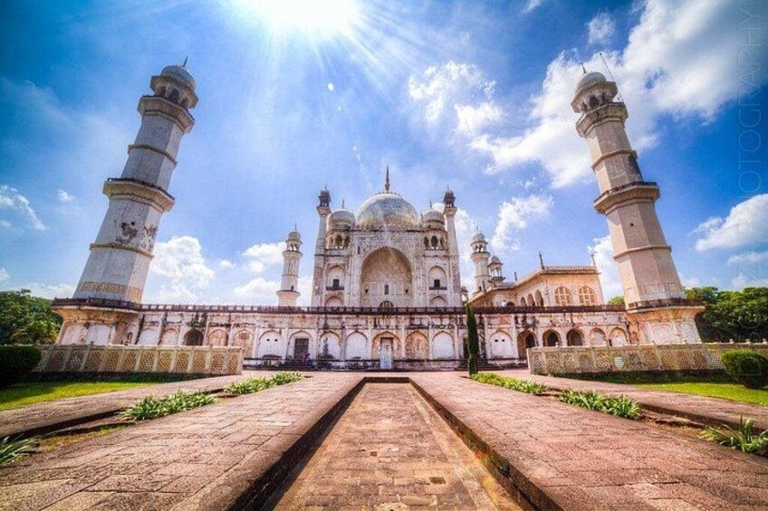 A large white building with multiple domes and minarets, surrounded by a paved walkway. 5