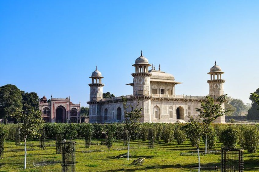 Ein großes, historisches Gebäude mit Kuppeln und Minaretten, umgeben von einem gepflegten Garten. 2