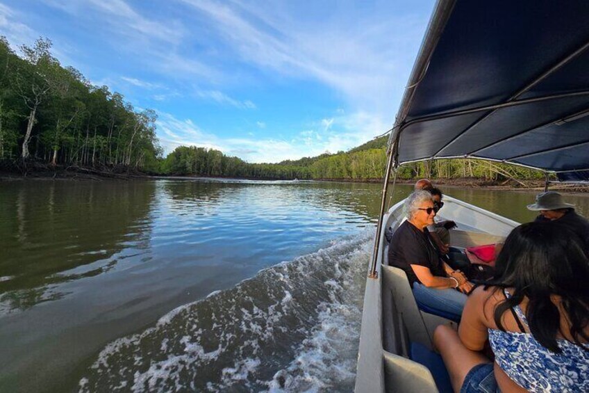 Een boot op een kalme rivier, met passagiers aan boord. 2