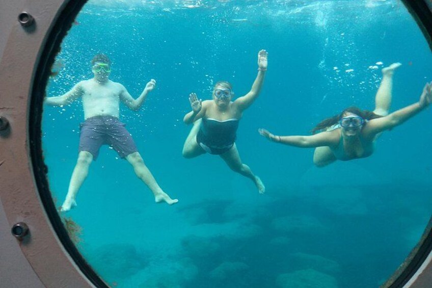 Three people swimming in a pool. 1