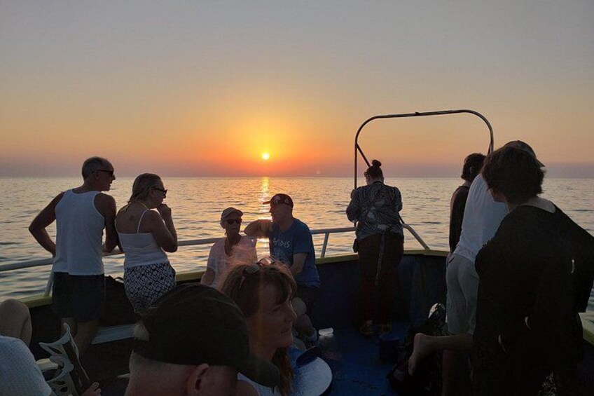 A group of people on a boat during sunset. 5