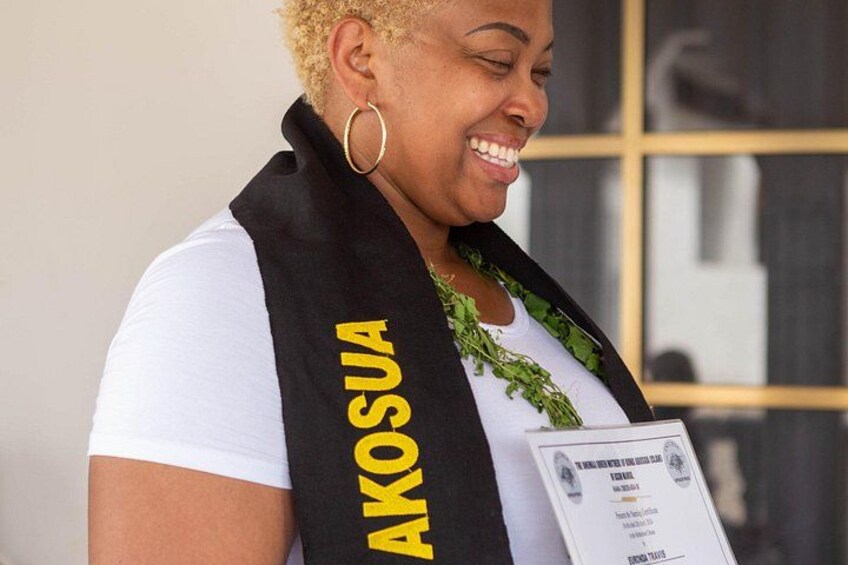 A person wearing a black and yellow sash with the word 'AKOSUA' on it, holding a document. 5