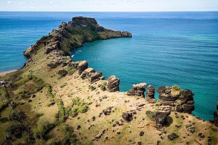 Eine Küstenlandschaft mit Felsformationen und tiefblauem Meer. 3