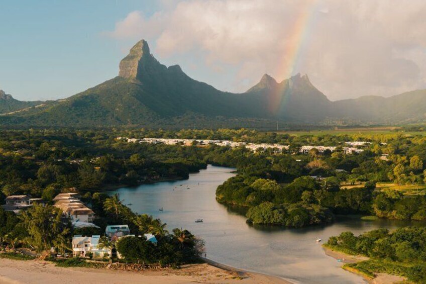 A river, mountains, a rainbow, and a coastal area with buildings. 1