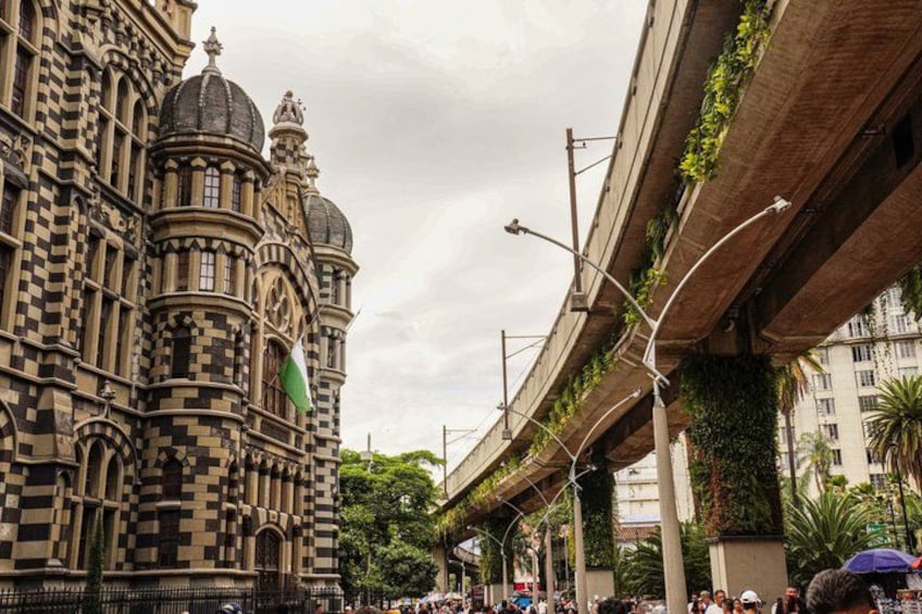 A historic building with ornate architecture, an elevated highway, and greenery. 4