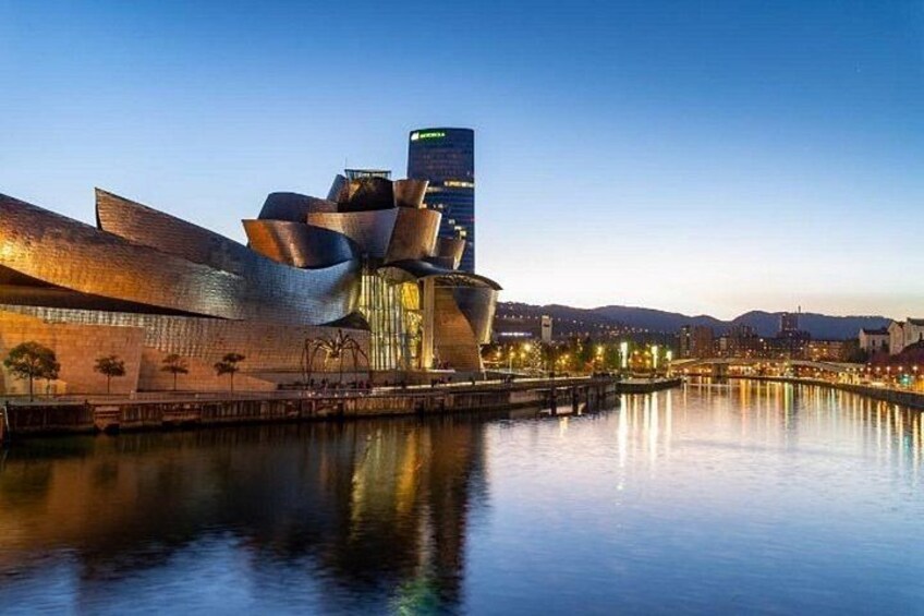 A modern architectural building with a unique design, situated by a calm body of water, reflecting the structure. 3