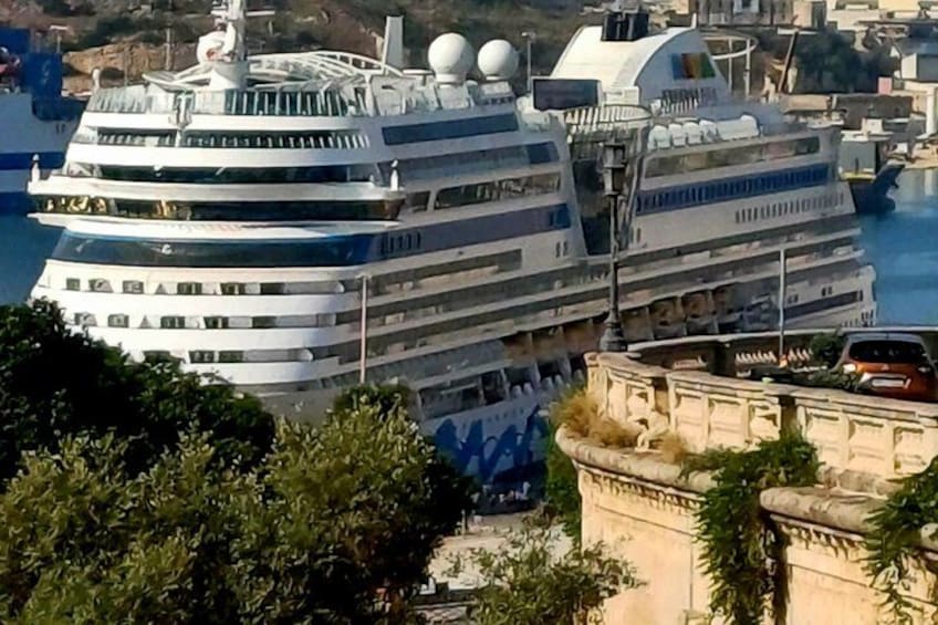 Un gran crucero amarrado en un puerto con un paisaje urbano al fondo. 5