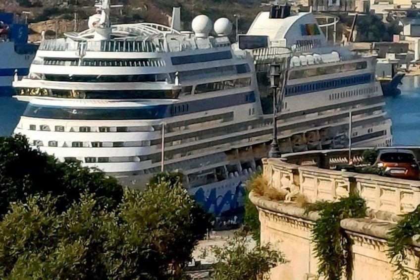 Un gran crucero amarrado en un puerto, con un paisaje urbano de fondo. 5