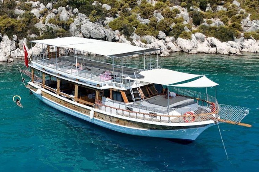 A boat with a white canopy, wooden deck, and a flag. 3