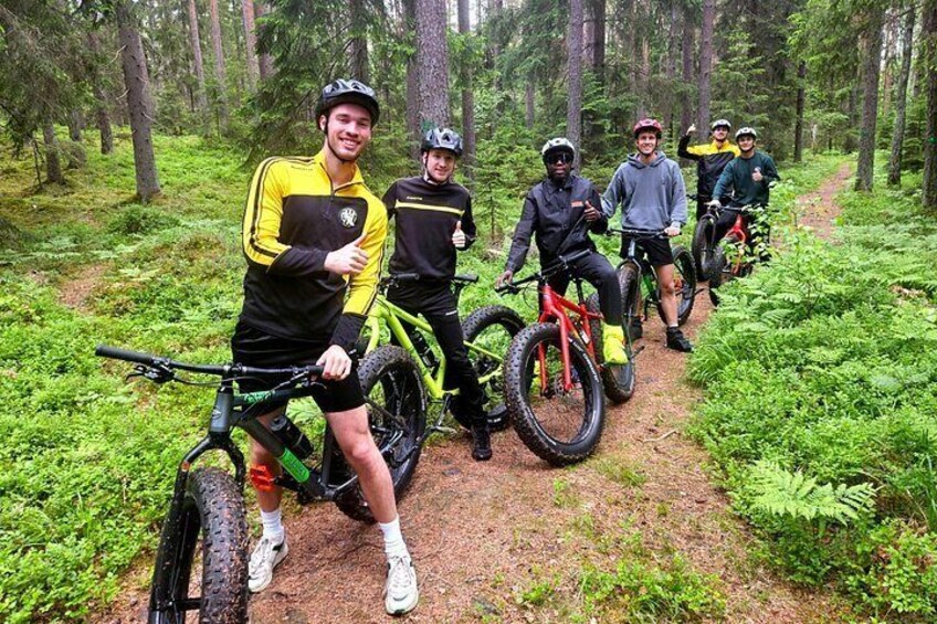 En grupp mountainbikecyklister på en stig i skogen. 1
