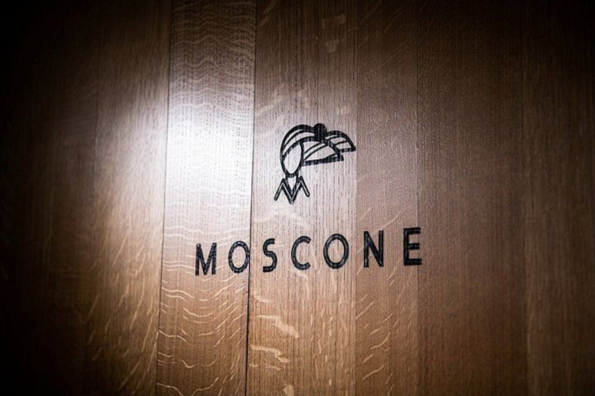A wooden surface with the word 'MOSCONE' and a logo. 4