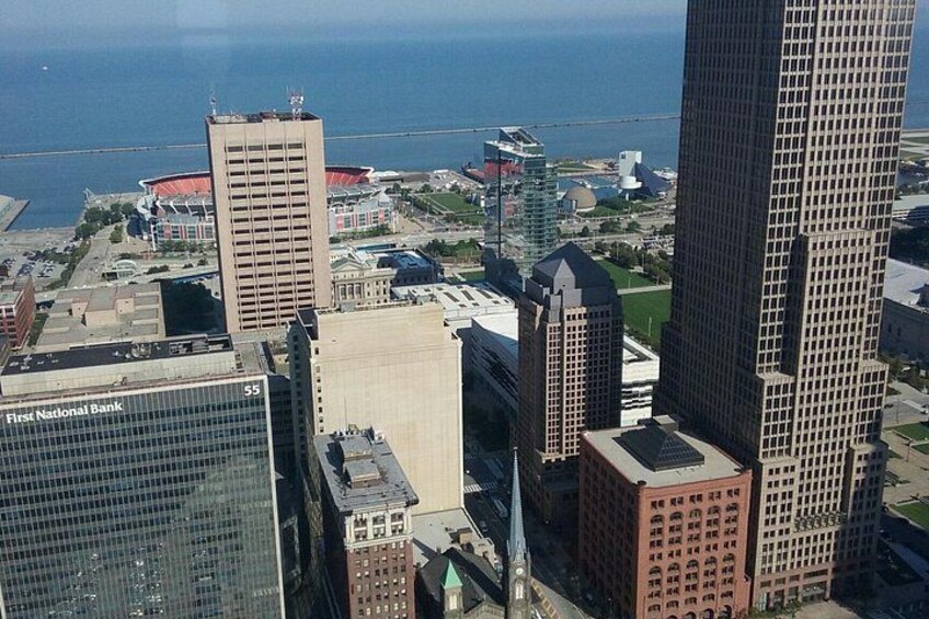 A cityscape with tall buildings, including a First National Bank, and a stadium in the background. 4