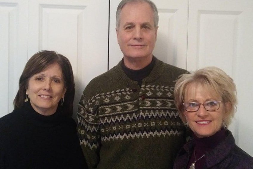 Three people standing in front of a white door. 2