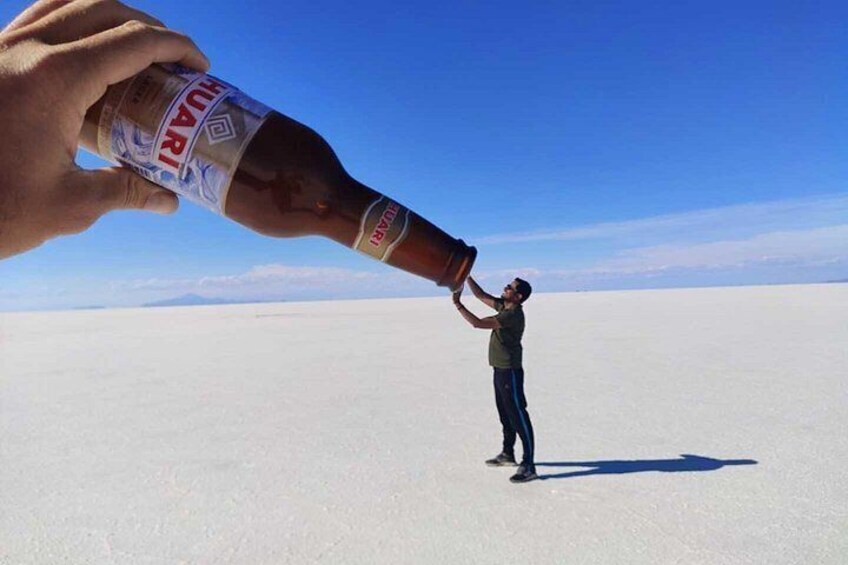 A person in a vast, flat, white landscape with a clear blue sky. 3