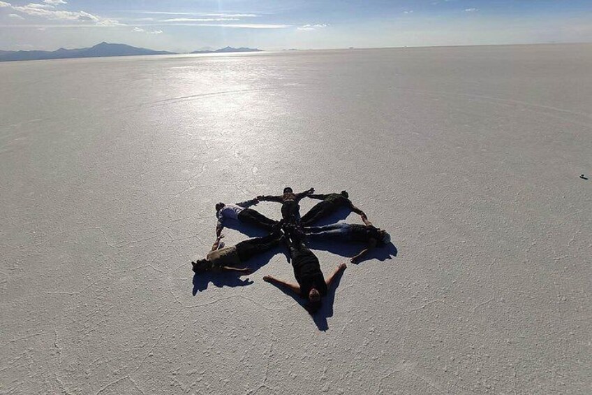 A person suspended in the air by a parachute in a vast, flat landscape. 2