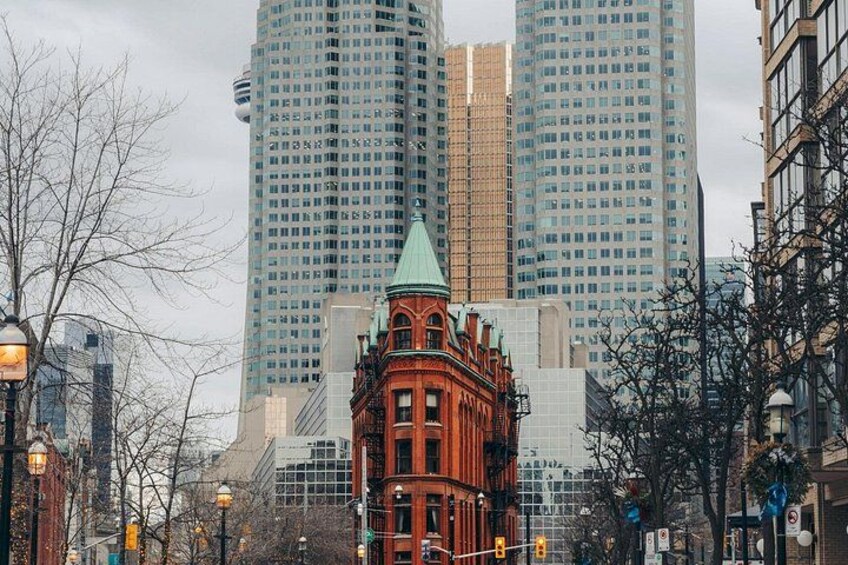 A cityscape with a historic red building in the foreground and modern high-rise buildings in the background. 4