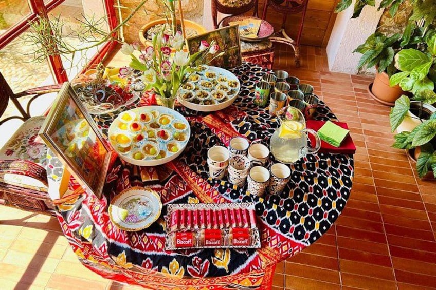A traditional Moroccan table set with various dishes, a teapot, and a colorful tablecloth. 2