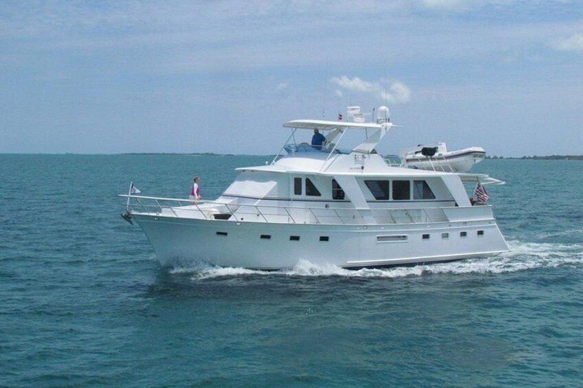 A white yacht on the water with a person standing on the deck. 4