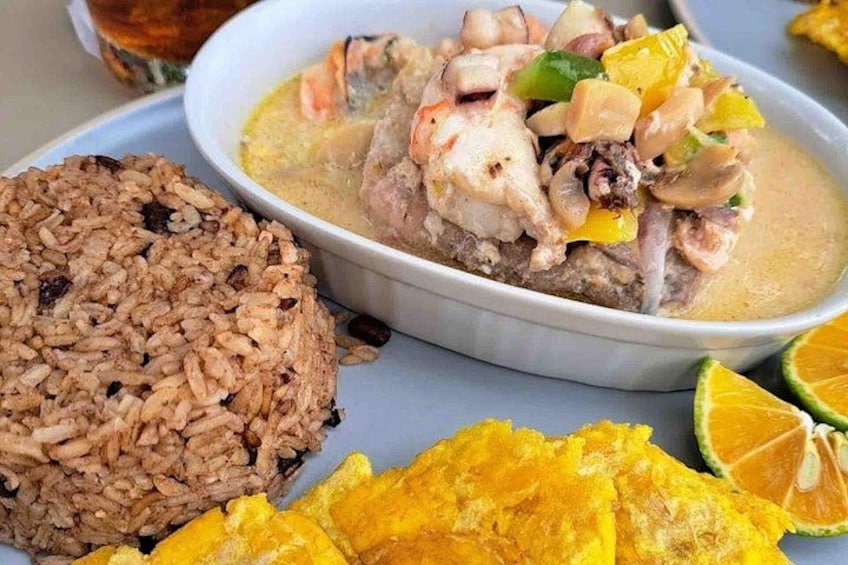 Un plato de arroz, una sopa de pollo y verduras, y una rodaja de naranja. 3