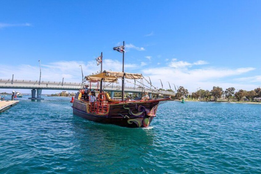 Un bateau traditionnel est amarré à un quai, avec un pont en arrière-plan. 1