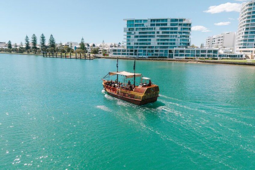 Un bateau sur une eau turquoise, avec des bâtiments en arrière-plan. 2