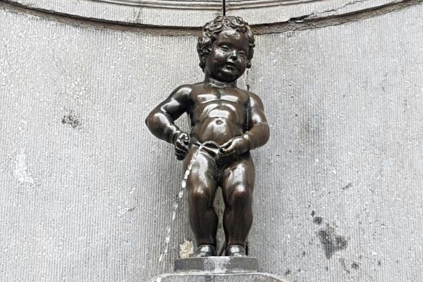 A bronze statue of a child with water flowing from its hands. 2