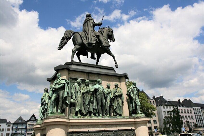A statue of a man on a horse with a group of figures below. 3