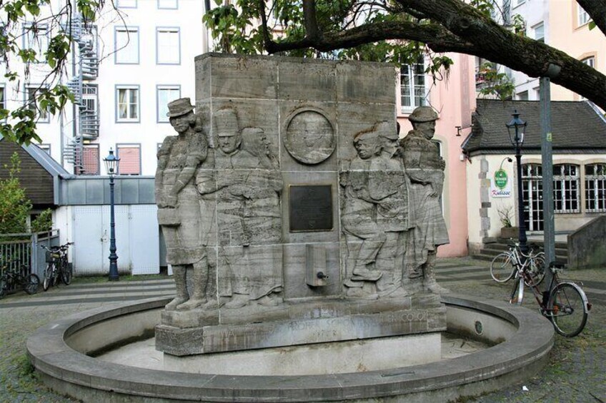 A stone monument with relief sculptures of soldiers and a circular emblem. 5