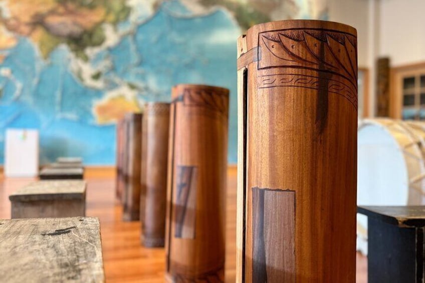 A row of wooden stools with intricate carvings, set against a backdrop of a world map. 2