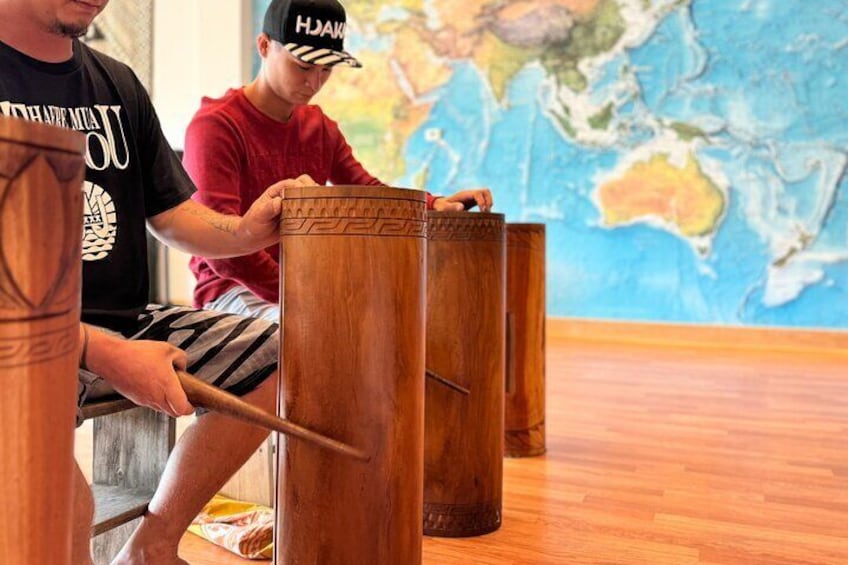 Two people playing maracas in a room with a wooden floor and a world map on the wall. 1