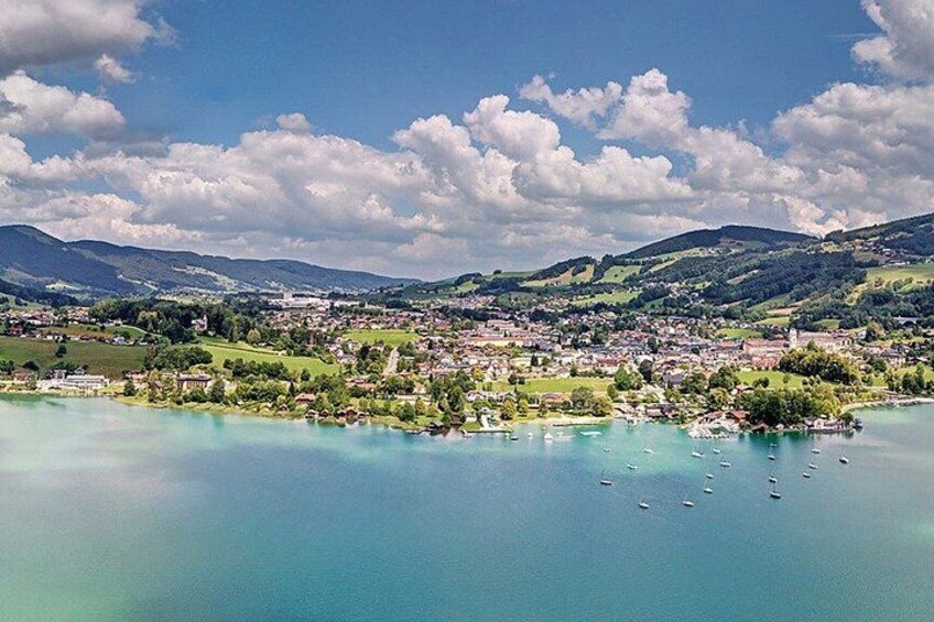 Un lac avec des bateaux, une ville et des montagnes en arrière-plan. 4