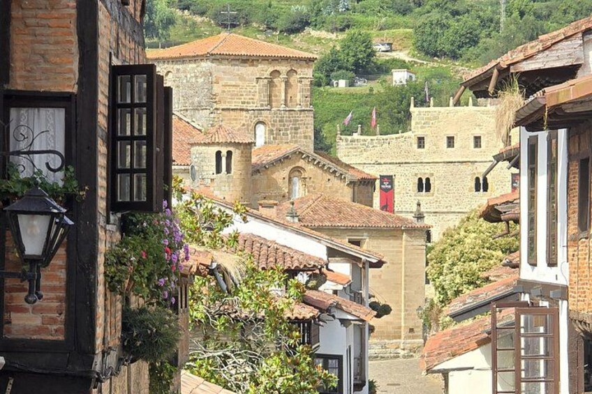 A town with historic buildings, a prominent church, and lush greenery. 2