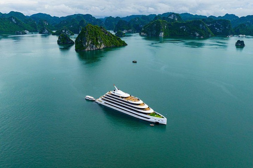 A large cruise ship sailing in calm waters surrounded by lush green islands. 5