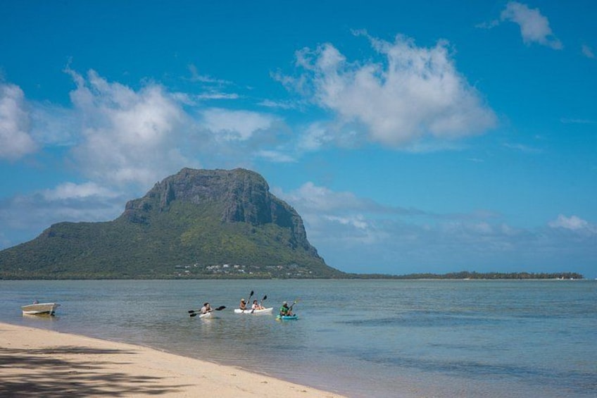 A beach with kayaks, a boat, and a mountain in the background. 3